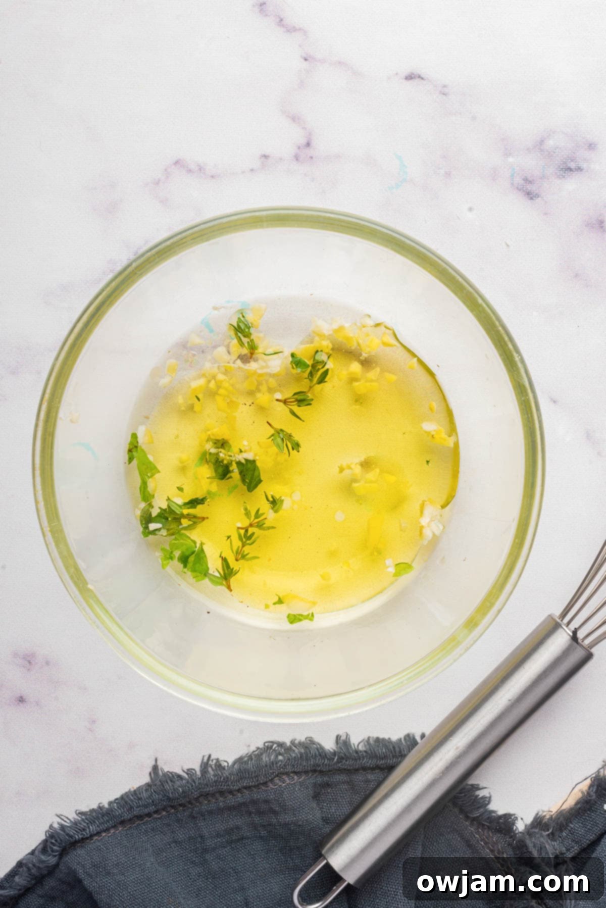 Freshly prepared herby vinaigrette dressing in a small bowl, ready to be drizzled over the salad.