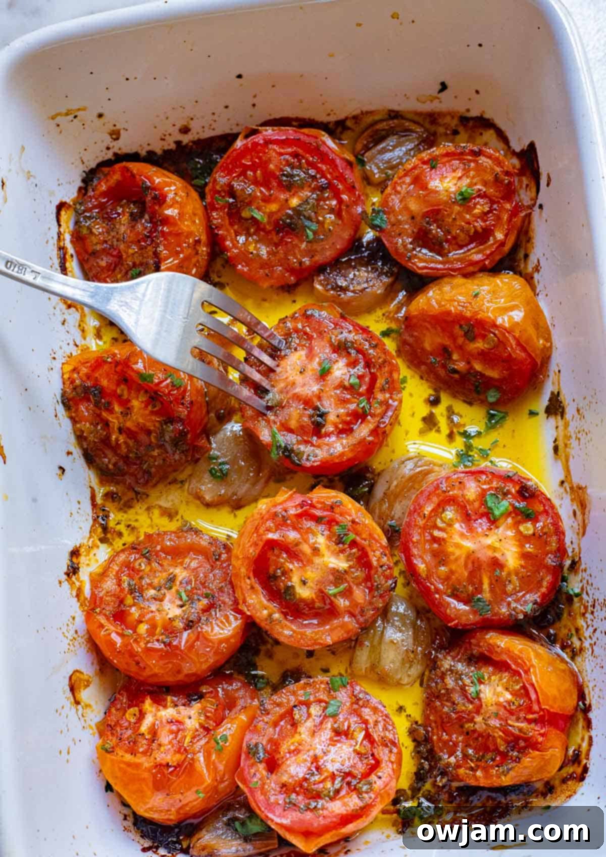Sweet Oven Roasted Tomatoes 5 Oven Roasted Tomatoes in a pan with a fork.