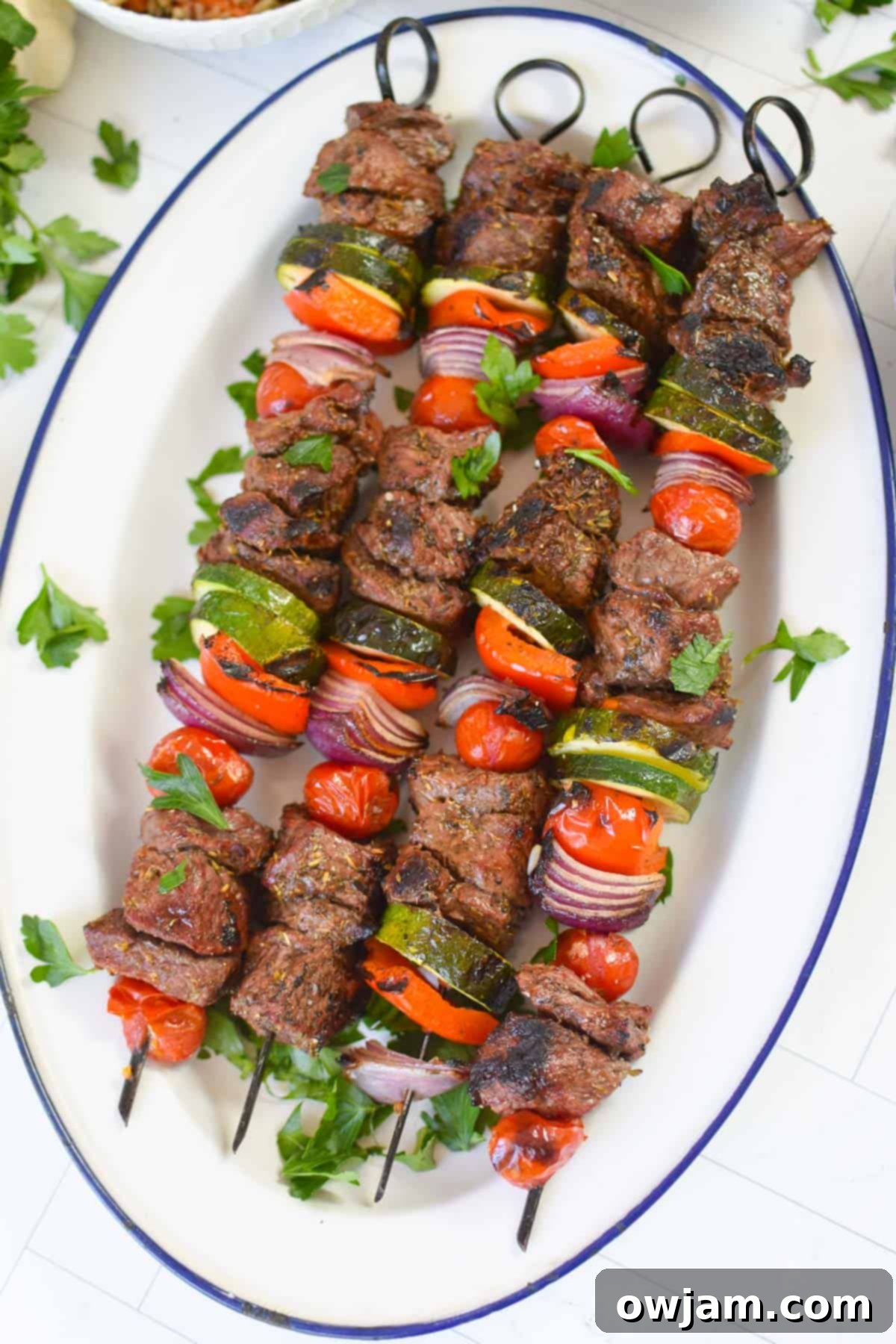 Authentic Greek Beef Souvlaki 12 Beef Souvlaki on a white platter with lemon wedges