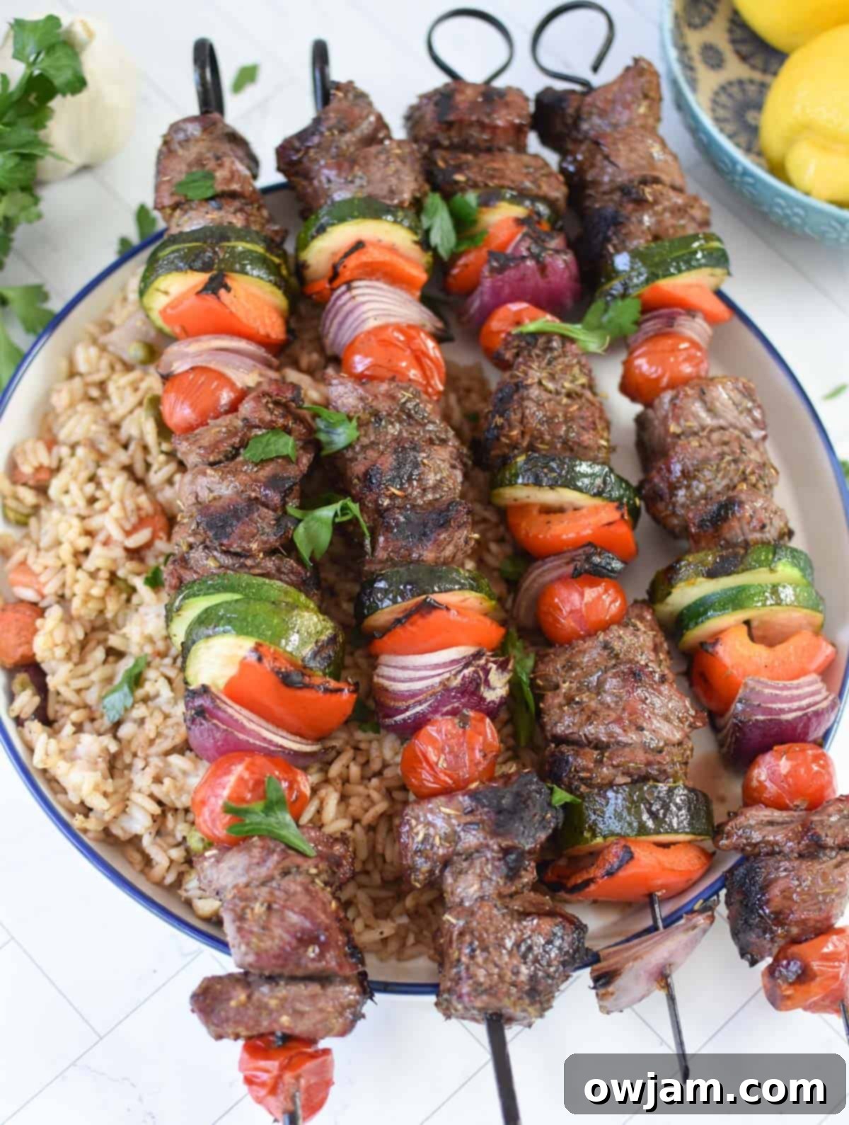 Authentic Greek Beef Souvlaki 3 Beef Souvlaki served over a bowl of rice with fresh herbs