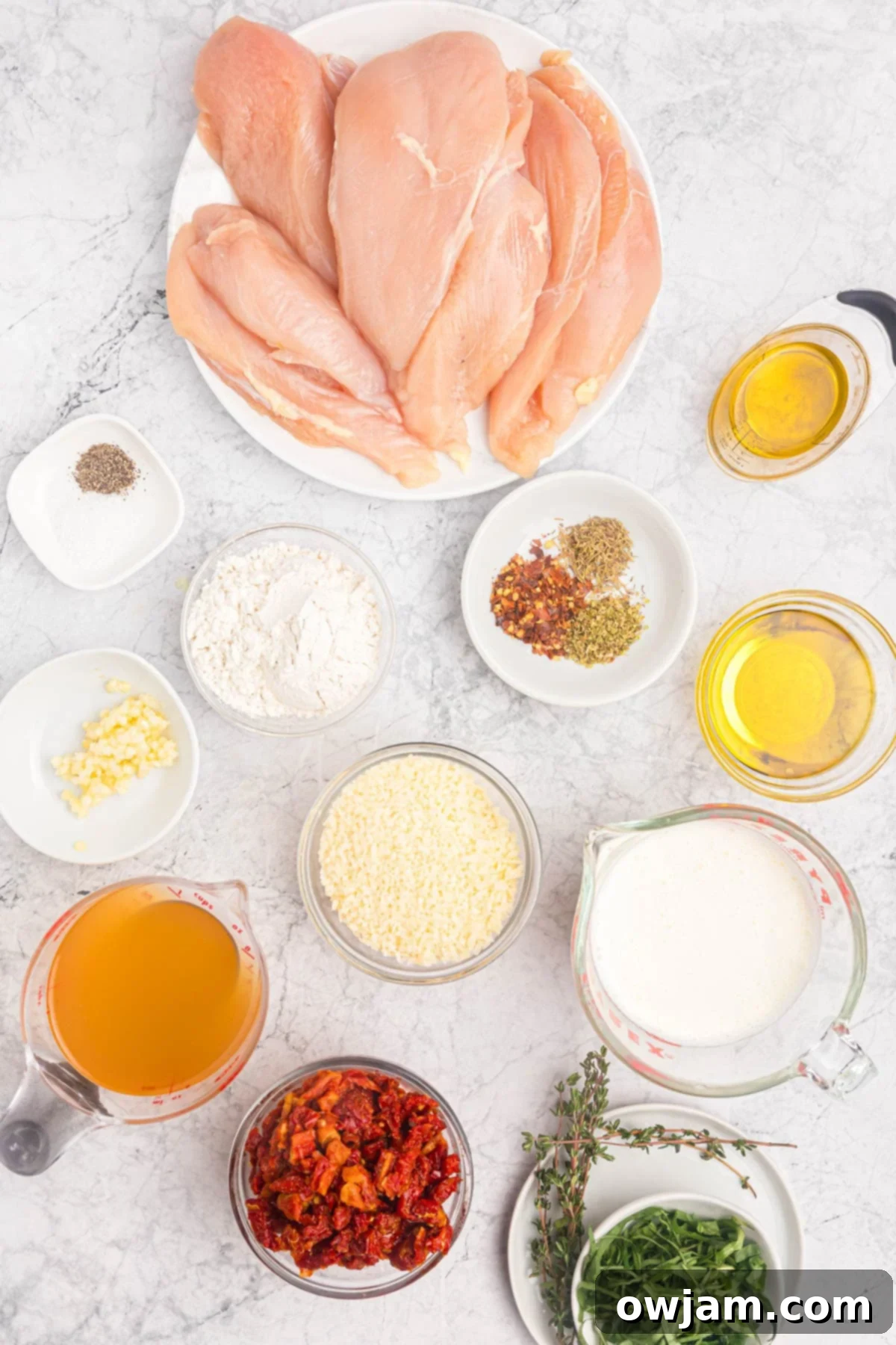 A selection of Marry Me Chicken ingredients laid out, including chicken, sun-dried tomatoes, cream, and herbs.