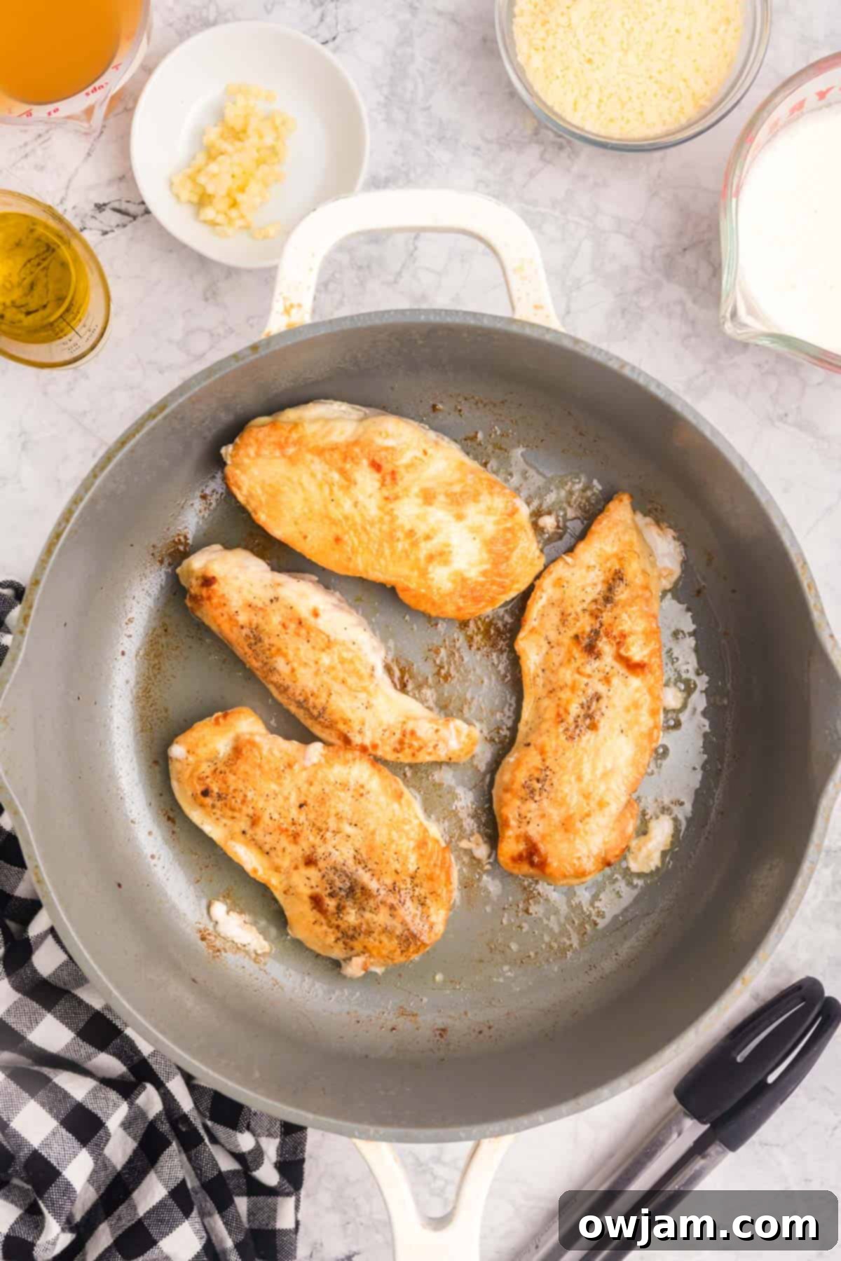 Chicken cutlets searing in a hot skillet, developing a golden-brown crust.