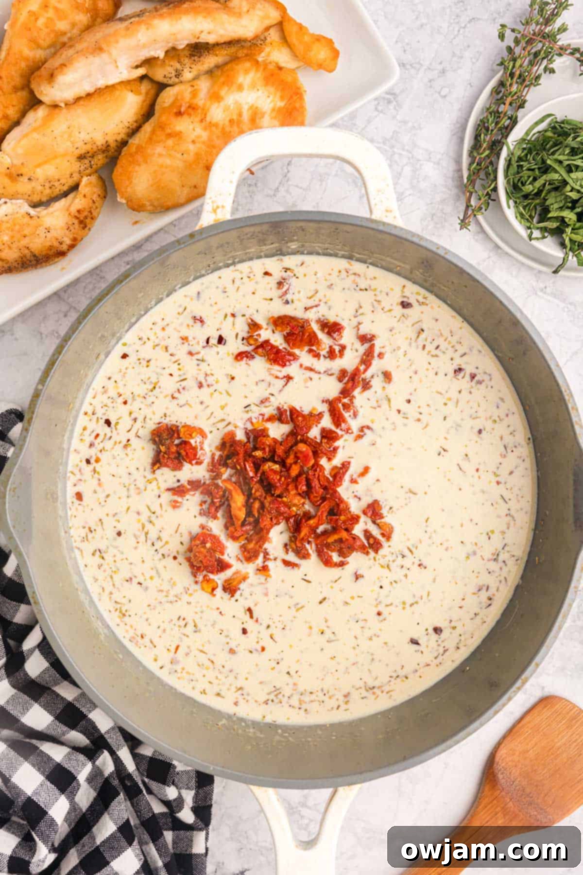 The creamy Marry Me Chicken sauce simmering in a skillet, showcasing its rich texture and color.