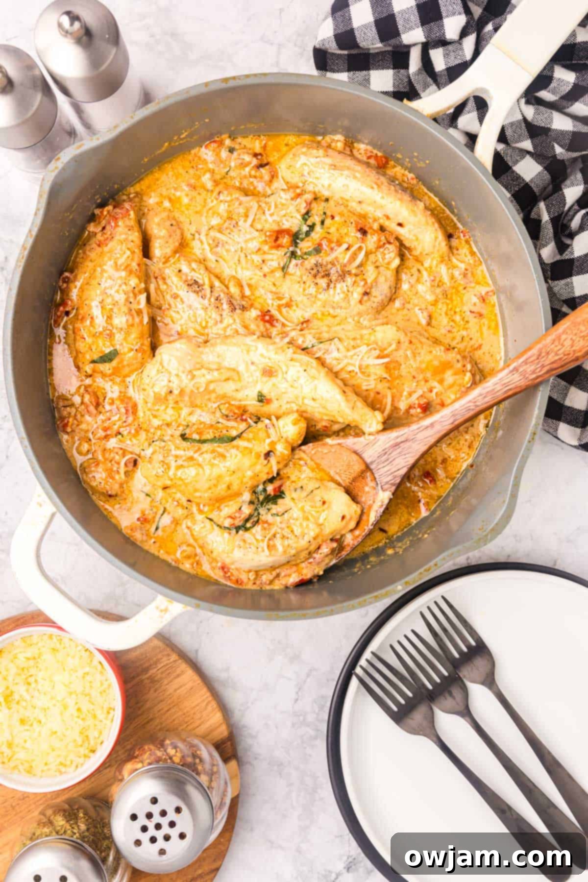 Marry Me Chicken simmering in a skillet, surrounded by creamy sauce and sun-dried tomatoes.