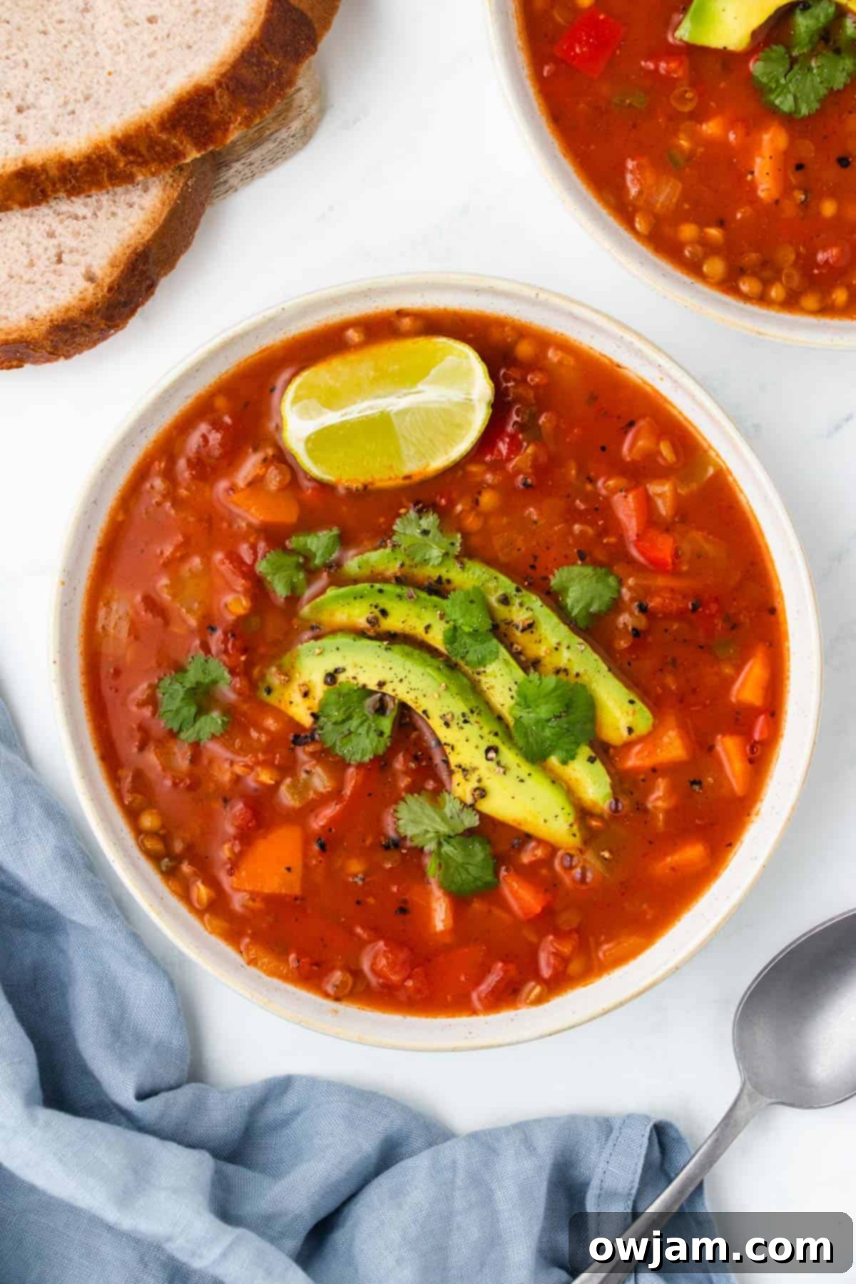 Mexican Lentil Soup 2 A bowl of vibrant Mexican Lentil Soup garnished with fresh avocado slices and cilantro.