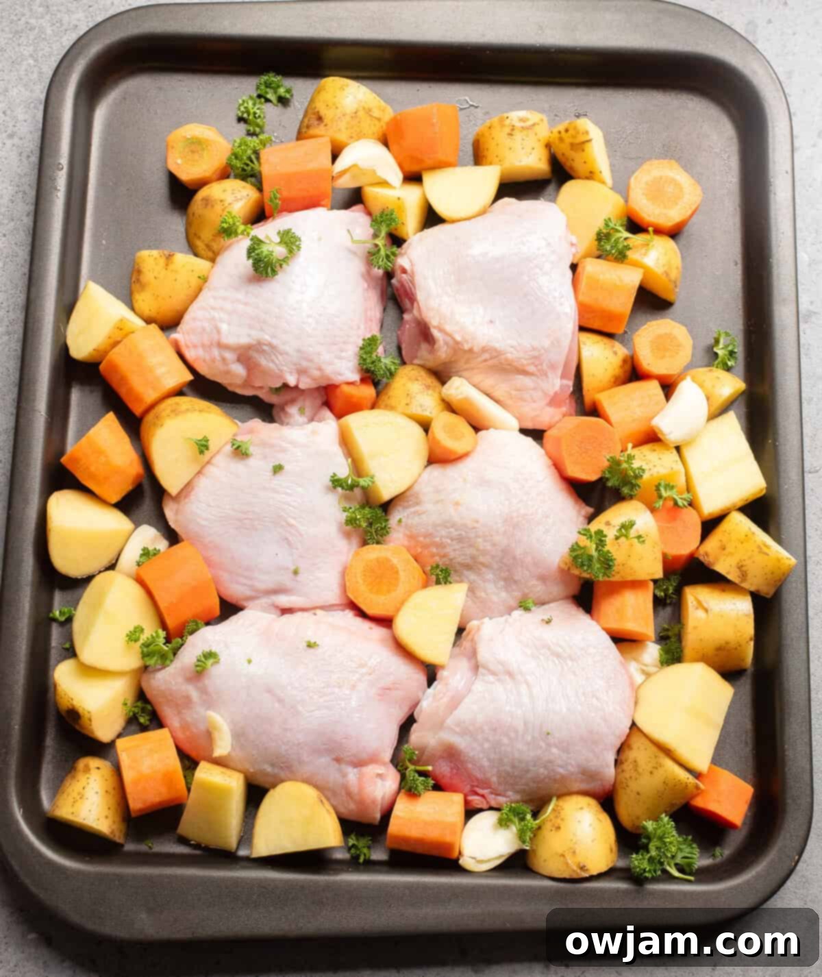 Easy Sheet Pan Honey Mustard Chicken Thighs 6 Sheet Pan Honey Mustard Chicken Thighs raw chicken on a baking sheet with veggies