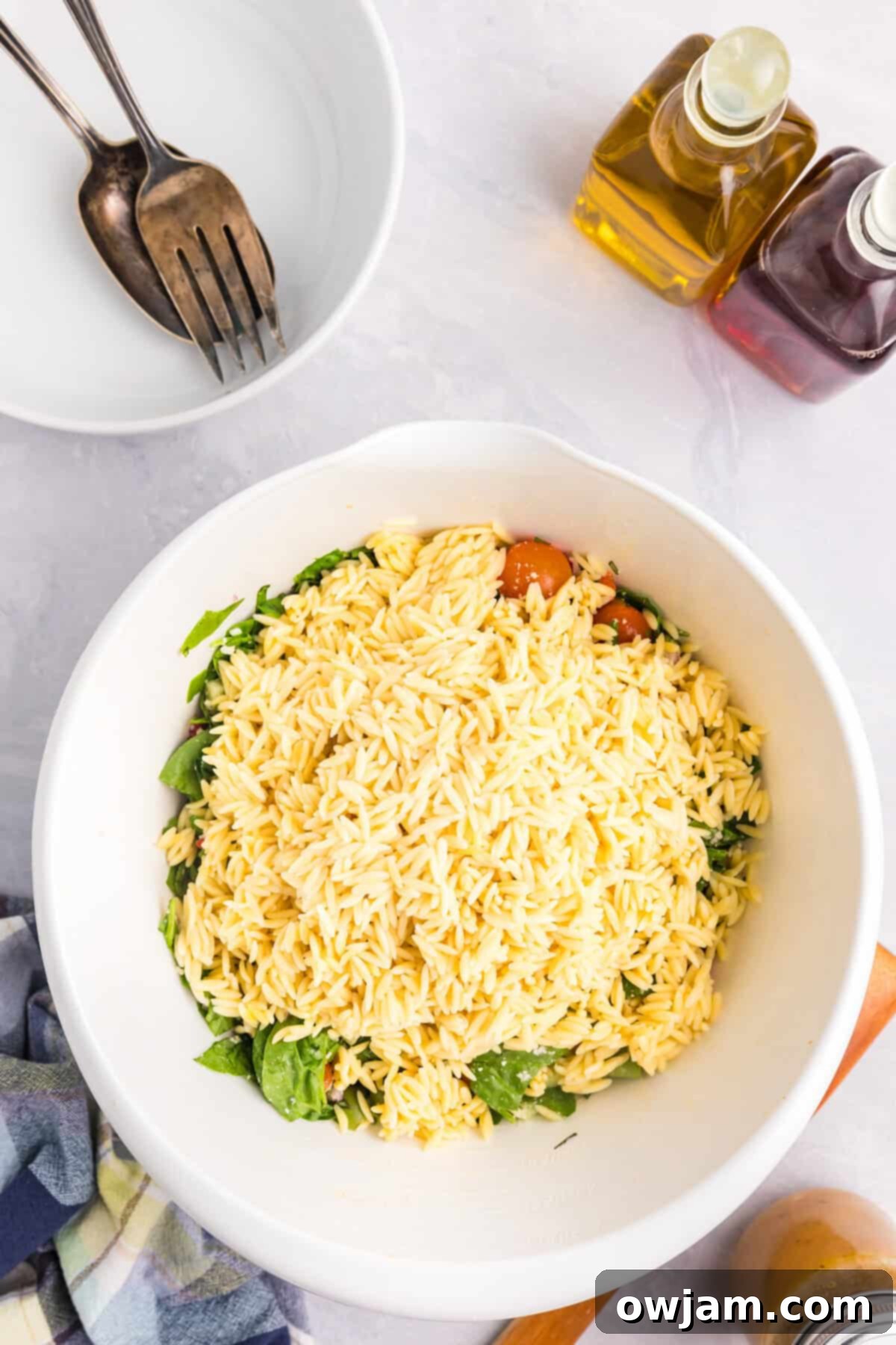 Sun-Kissed Mediterranean Pasta Bowl 7 Cooked orzo pasta added to a bowl of fresh Mediterranean salad ingredients, ready for dressing.