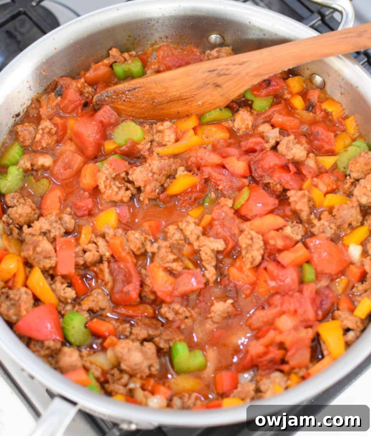 Creamy Cajun Sausage and Rice Skillet 7 Tomatoes and rice being added to the skillet for Creamy Cajun Sausage Rice Skillet
