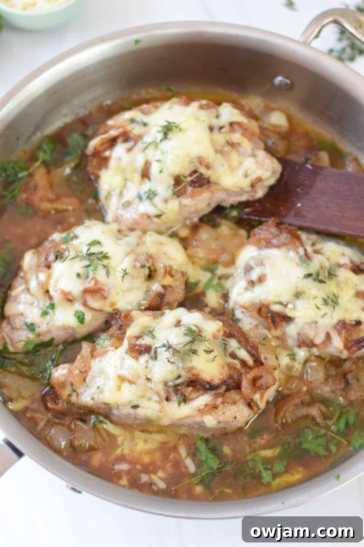 French Onion Pork Chops with a wooden spatula 