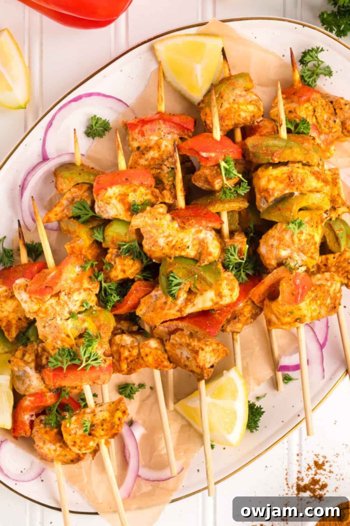 Flavorful Chicken Tikka Skewers 11 Chicken Tikka Kebabs on skewers on a plate