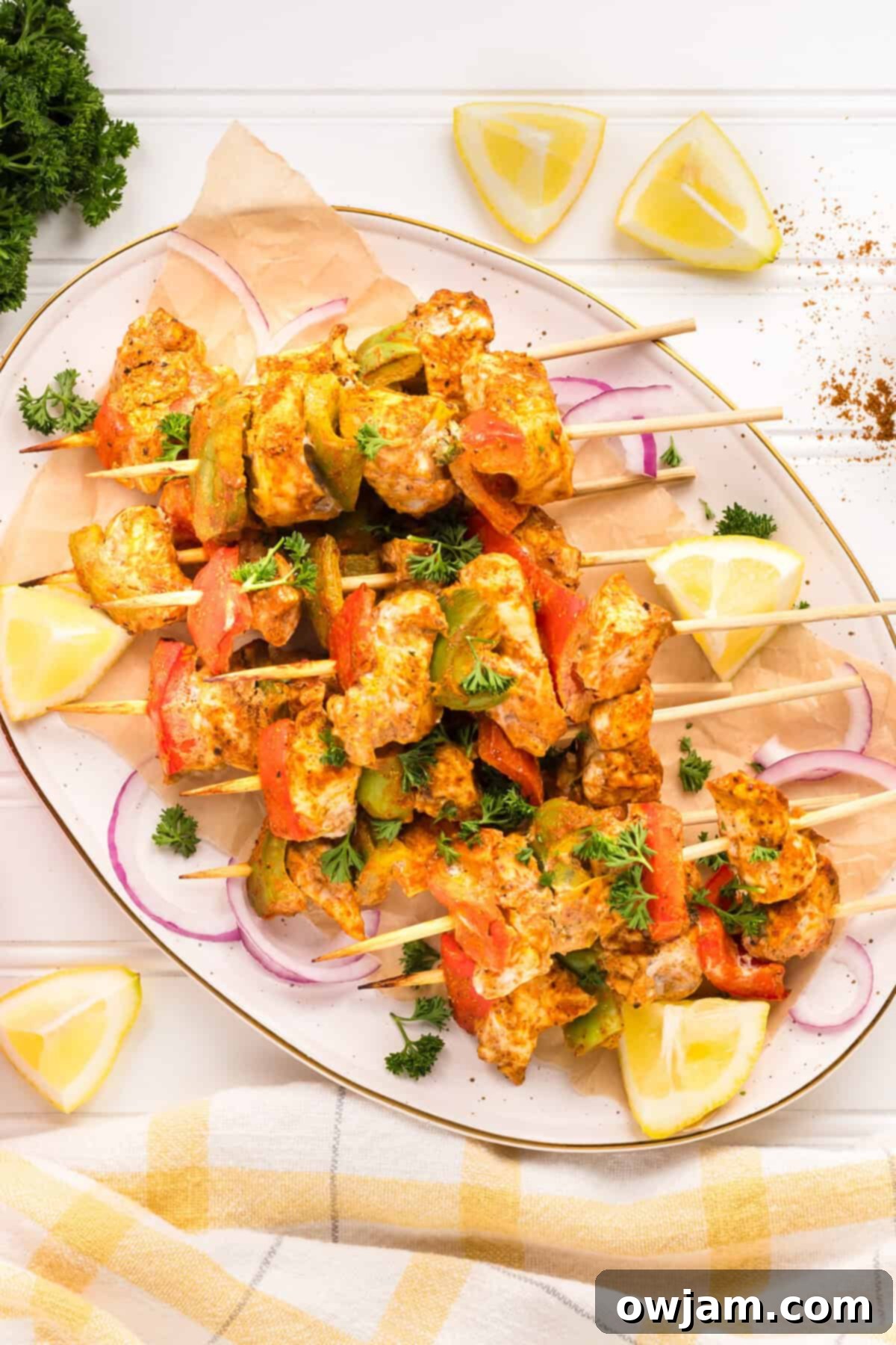 Flavorful Chicken Tikka Skewers 12 Chicken Tikka Kebabs on a plate with lemon wedges