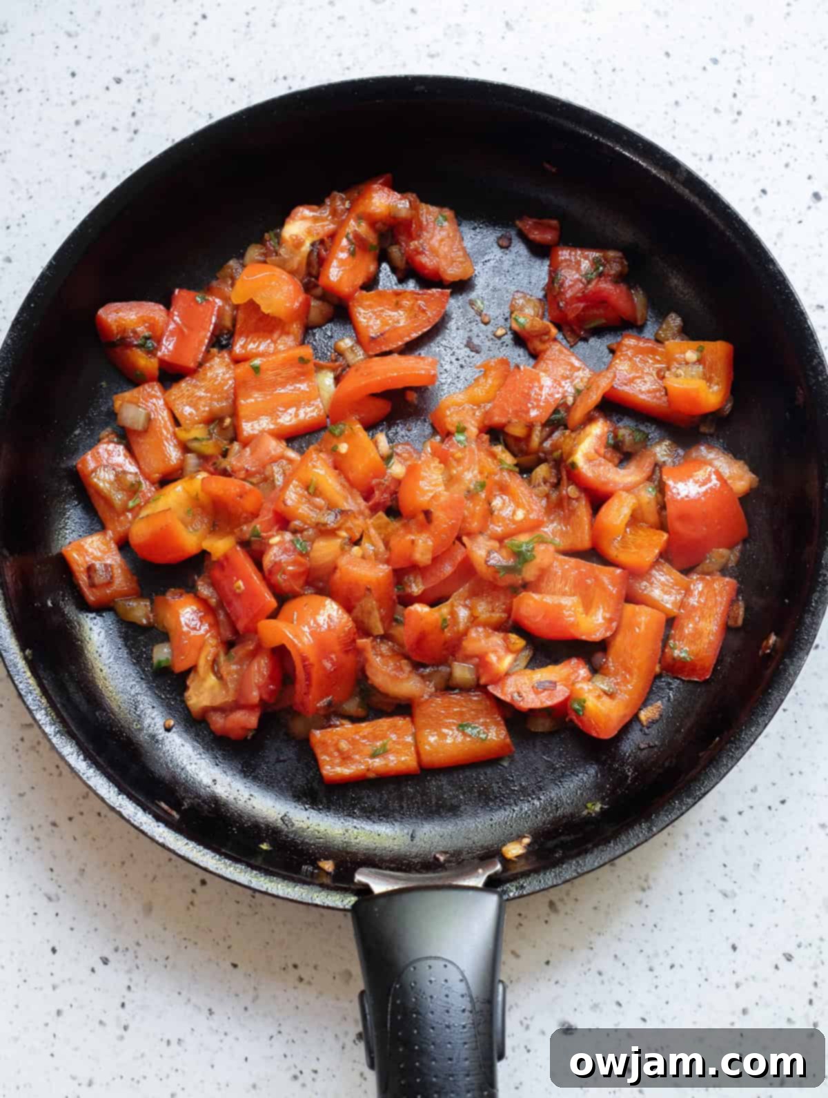 Luscious Coconut Fish Curry 7 Sautéed onions, garlic, red bell pepper, and tomatoes simmering in a skillet, forming the base of the curry.