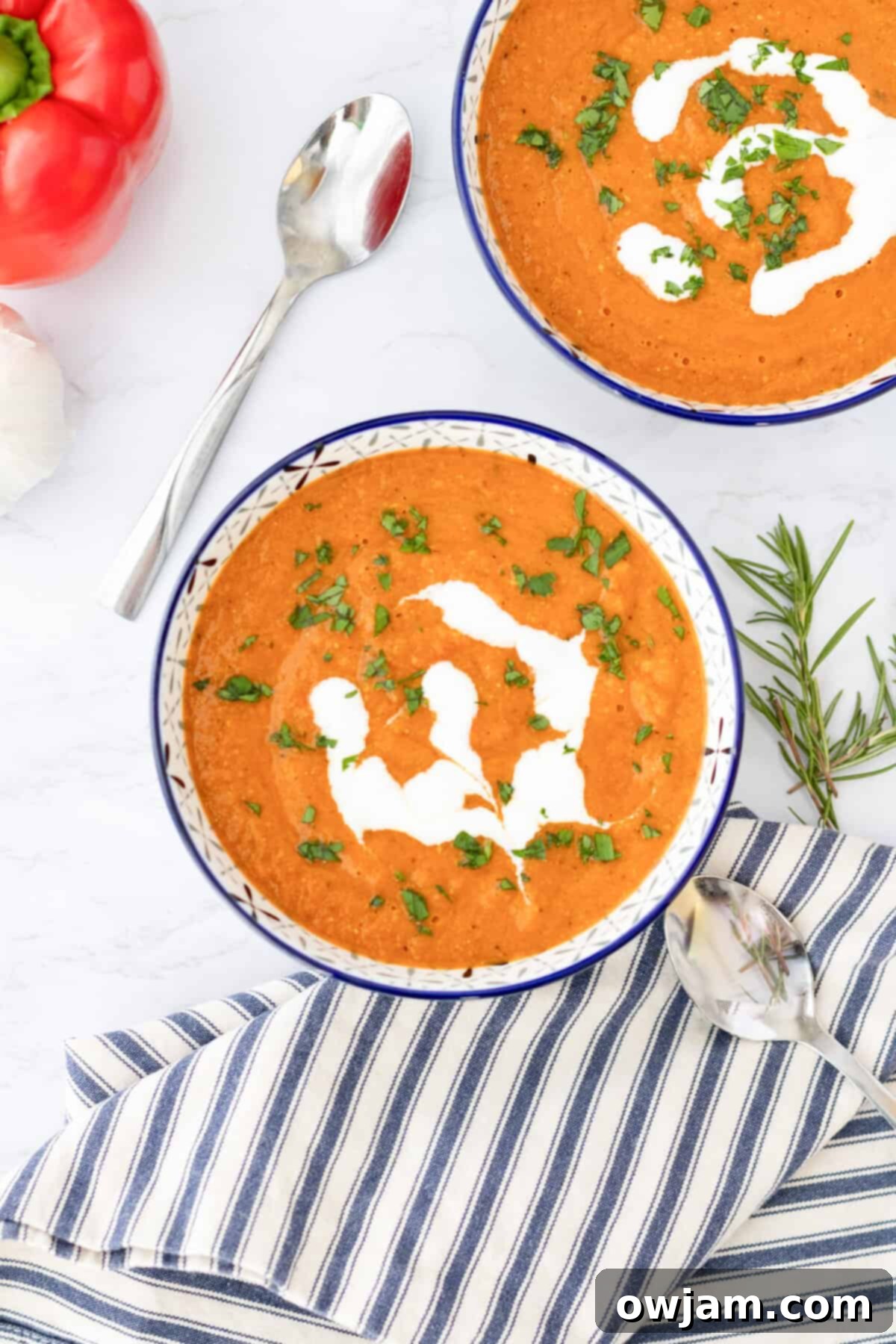 Spiced Tomato & Lentil Delight 3 Two bowls of Lentil Tomato Soup, one white and one blue, on a rustic wooden surface, highlighting its vibrant color.