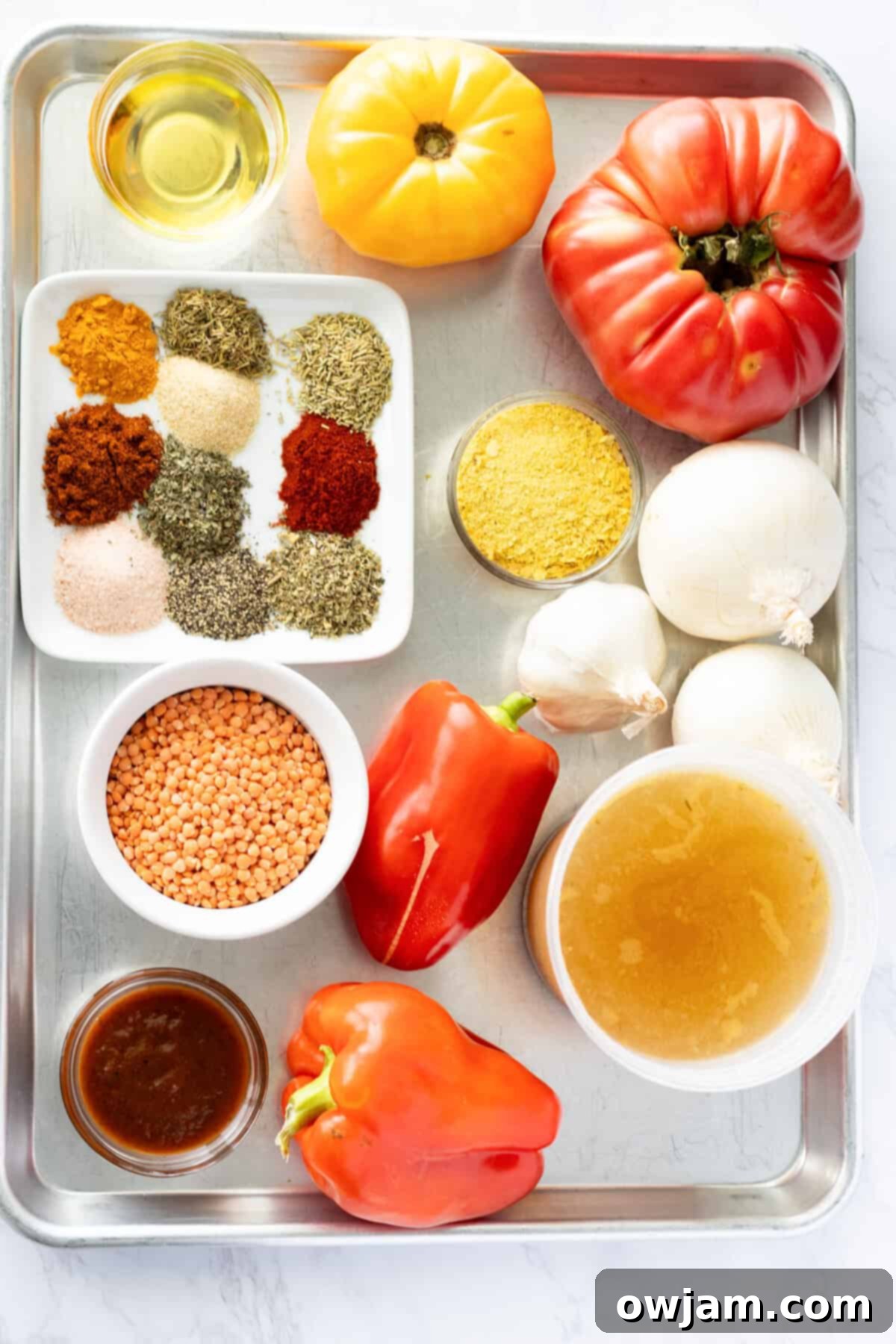 Spiced Tomato & Lentil Delight 4 A vibrant display of fresh ingredients for Lentil Tomato Soup, including tomatoes, bell peppers, garlic, onions, and various spices.