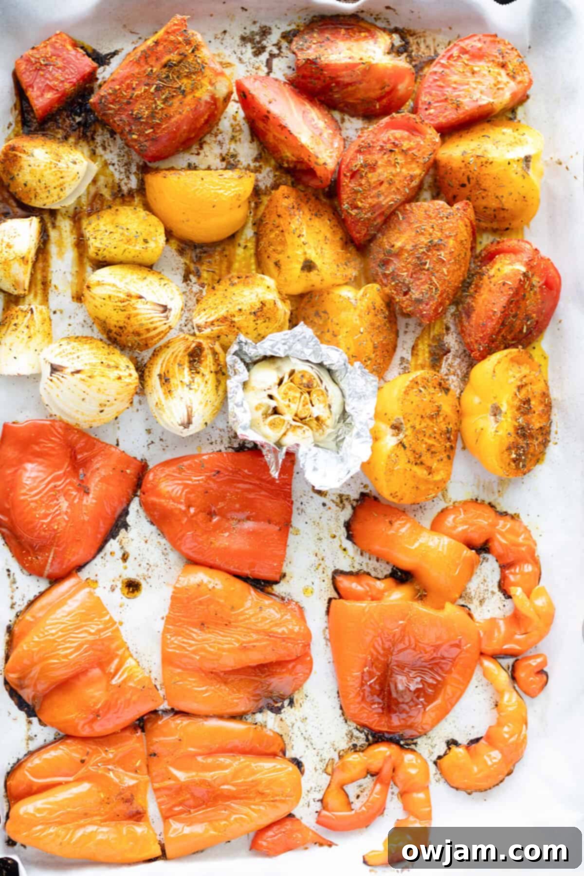 Spiced Tomato & Lentil Delight 6 Close-up of vegetables (tomatoes, peppers, onions) roasting on a baking sheet, with visible charring.