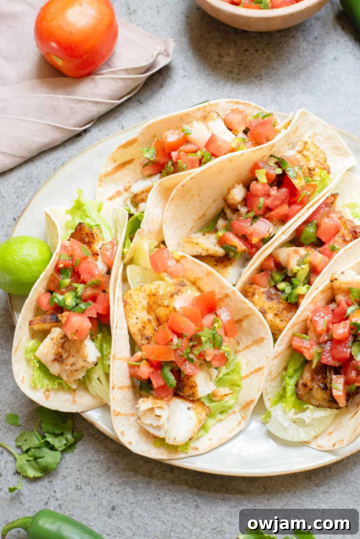 Flame-Kissed Fish Tacos 10 Blackened Fish Tacos on a plate with garnishes