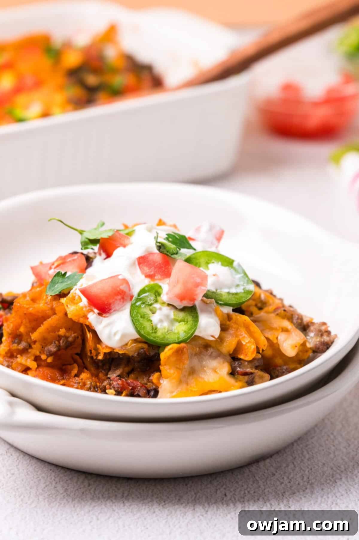 A close-up of a bowl of Doritos Taco Casserole, showcasing the layers of meat, cheese, and crunchy chips.