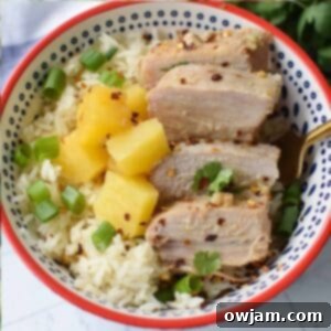 Hawaiian Pineapple Pork 8 Slow Cooker Pineapple Pork Loin in a white bowl, garnished with cilantro and sesame seeds.