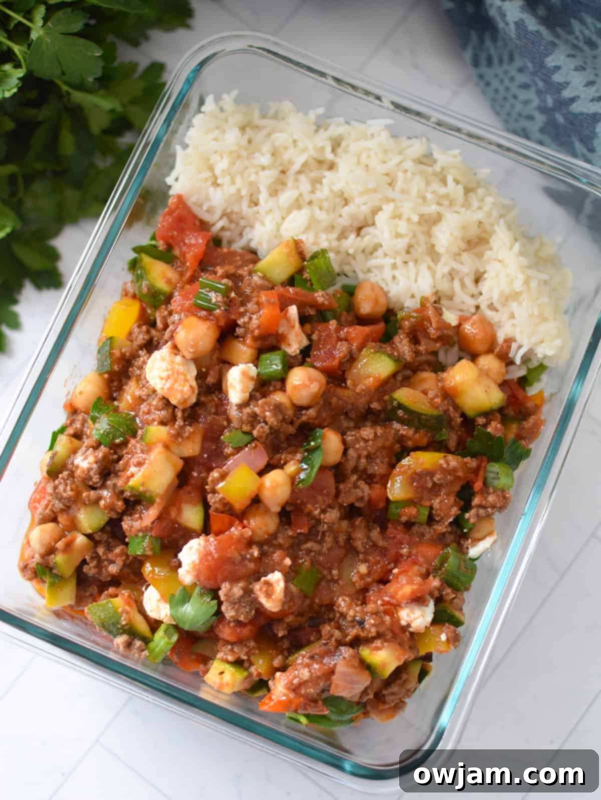 Leftover Mediterranean Ground Beef Skillet stored in a clear tupperware container, ready for easy meal prep
