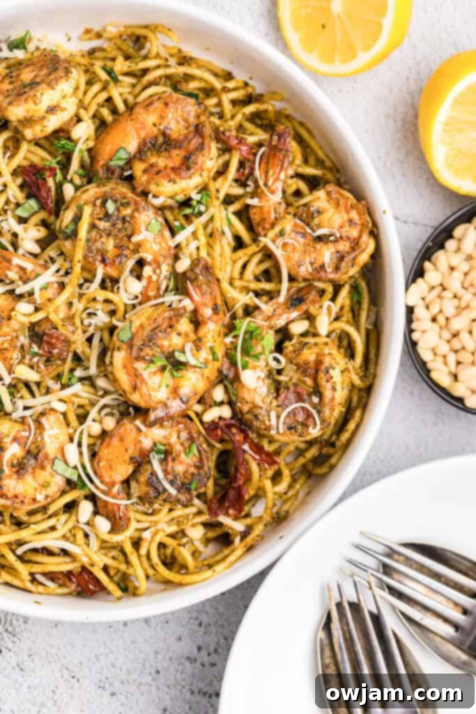A vibrant bowl of Shrimp Pesto Pasta, garnished with fresh basil leaves