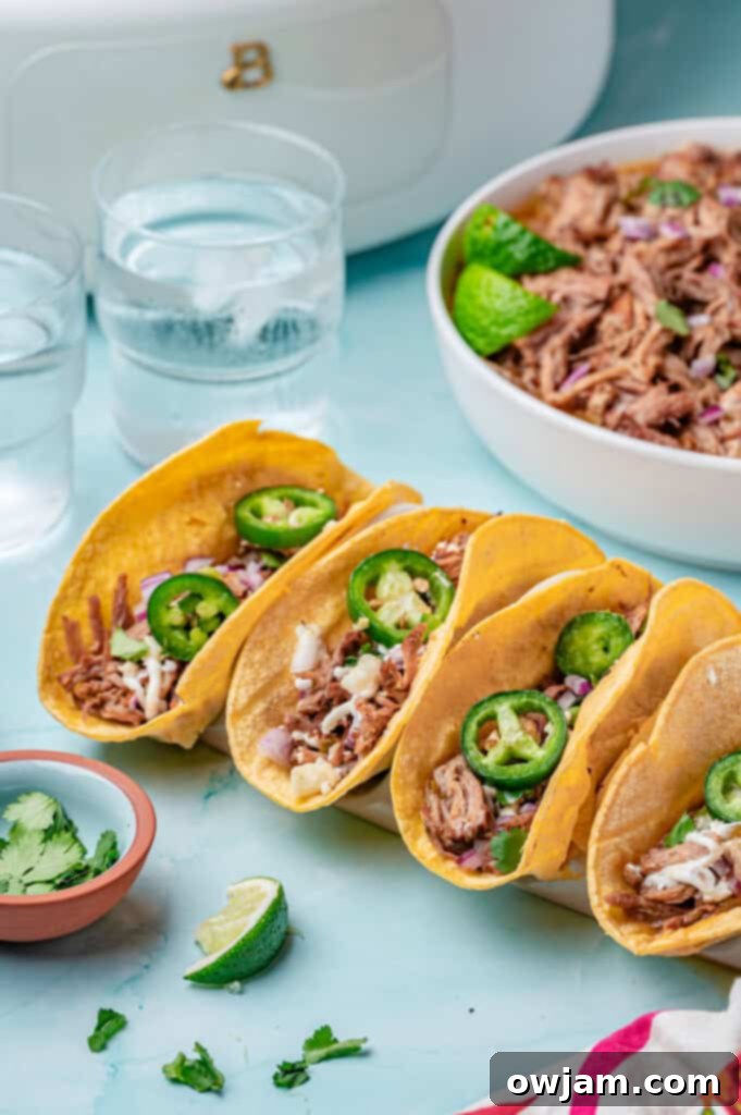 Slow Cooker Pulled Pork Tacos three tacos on a board 