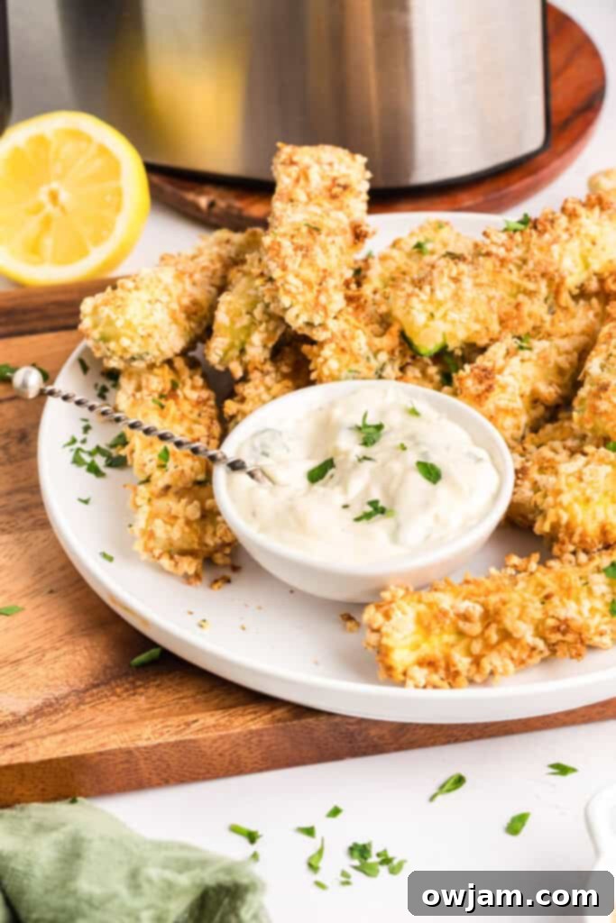 Crispy Air Fryer Zucchini Sticks 2 Crispy Air Fryer Zucchini Fries served on a plate with a side of aioli.