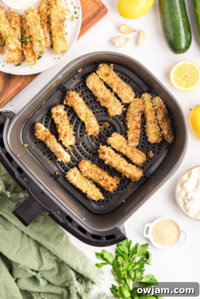Crispy Air Fryer Zucchini Sticks 14 Air Fryer Zucchini Fries cooking in a single layer in the air fryer basket.
