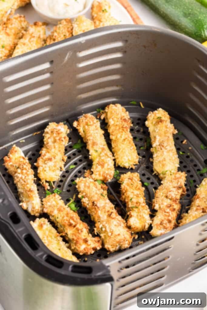 Crispy Air Fryer Zucchini Sticks 15 Air Fryer Zucchini Fries in the air fryer basket before being removed, golden brown and crispy.