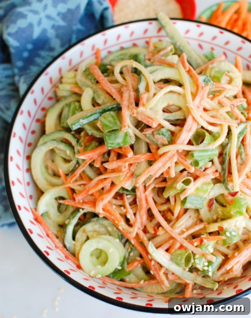 Large bowl of Sesame Noodles generously topped with various vegetables and garnished, ready to serve and share.