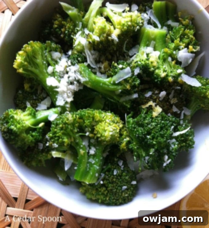 A vibrant bowl of steamed Lemon Parmesan Broccoli, glistening with lemon juice and sprinkled with cheese, ready to be served as a quick and healthy side dish.