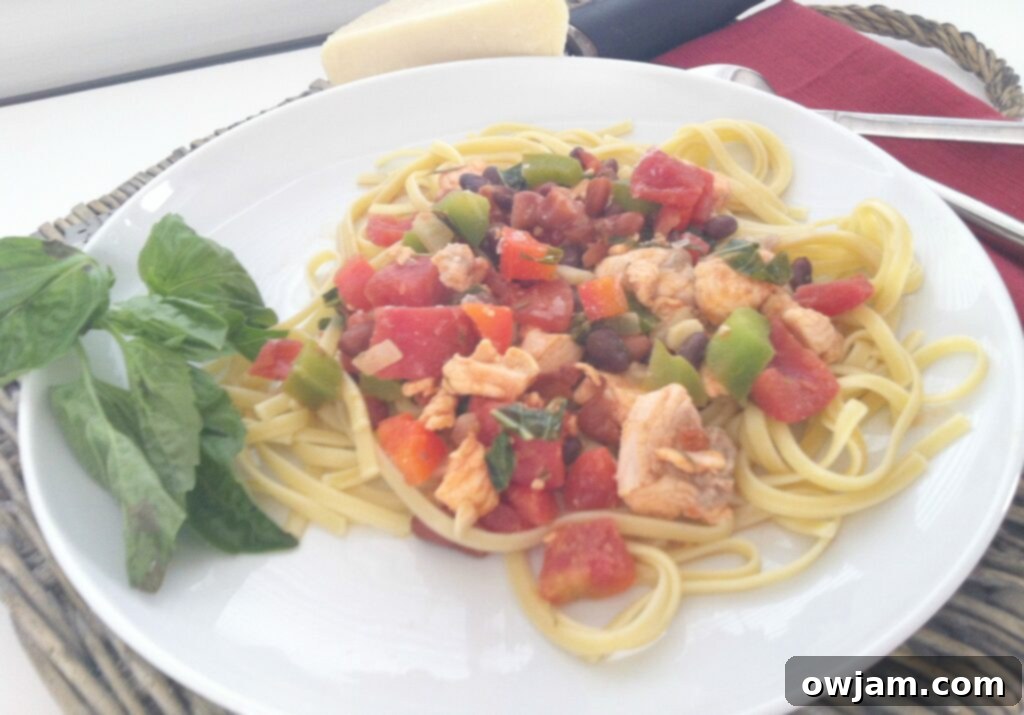 Close-up of cooked Salmon Pasta, showcasing succulent salmon pieces, vibrant bell peppers, and perfectly coated linguine strands in a light sauce.