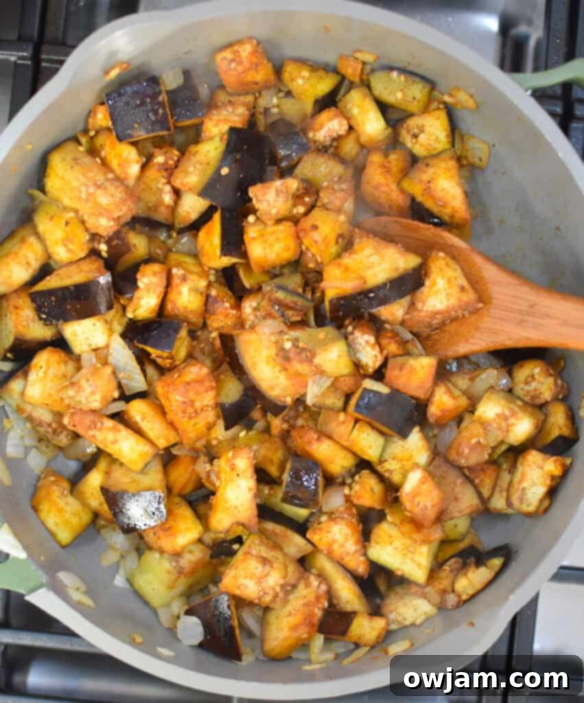 Lebanese Moussaka Maghmour 6 Eggplant and chickpeas cooking in a skillet, gently sautéing to soften and meld flavors.