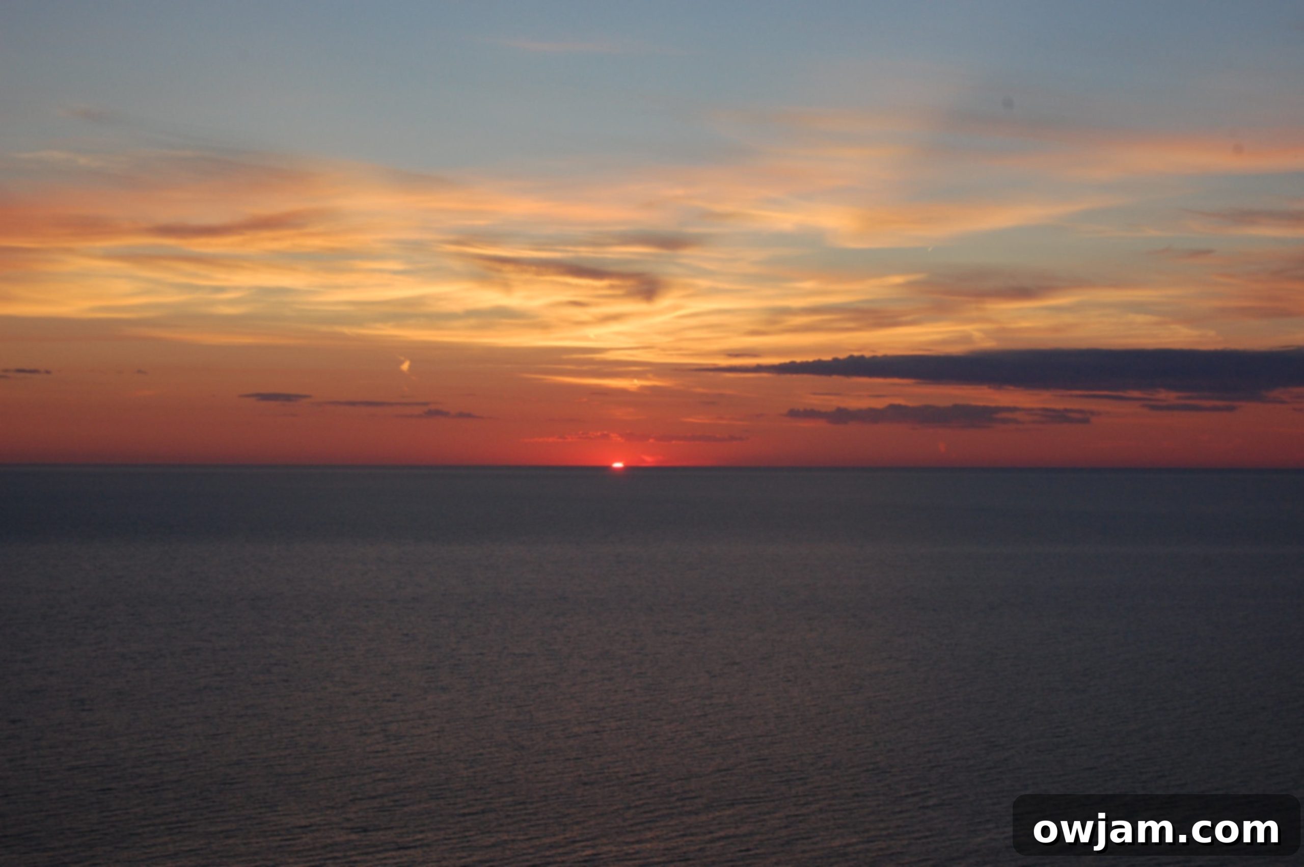 Serene sunset reflecting on the water at Sleeping Bear Dunes.