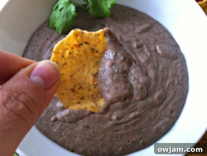 Overhead shot of Smoky Black Bean Dip with chips and lime wedges