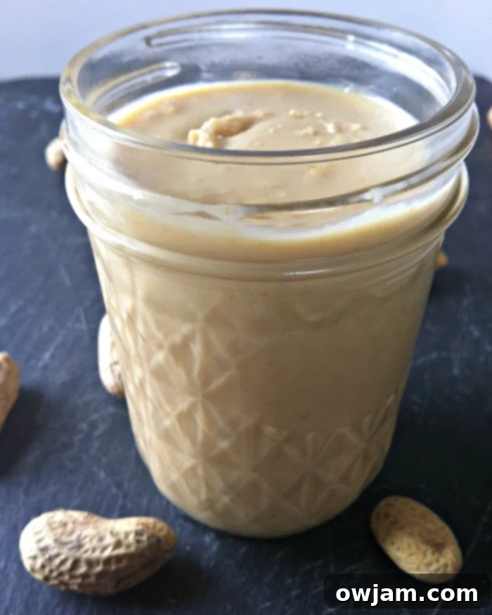 Jar of homemade peanut butter, freshly made and ready for storage.