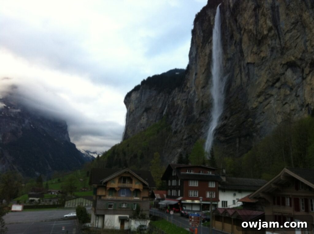 Lauterbrunnen Valley in Interlaken, Switzerland, showcasing lush green fields and towering cliffs with visible waterfalls.
