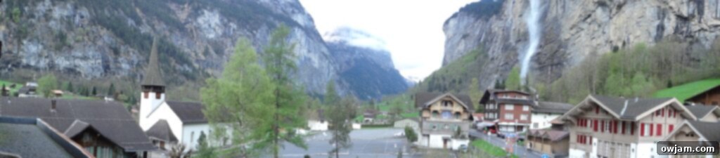 A broad panoramic view of Interlaken with a quaint townscape and surrounding mountains.