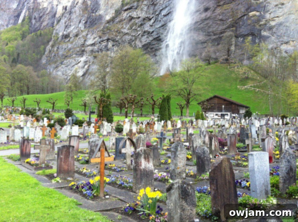 A serene cemetery in Lauterbrunnen, Switzerland, with headstones set against a backdrop of majestic mountains.