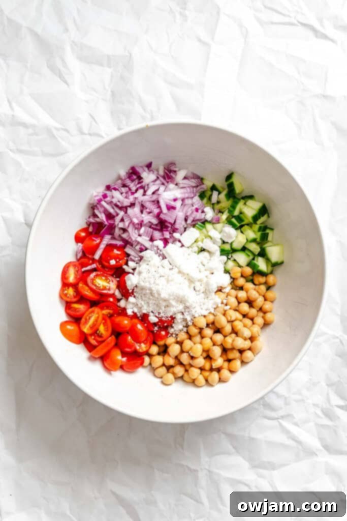 Fresh ingredients for Summer Orzo Pasta Salad in a bowl before mixing.