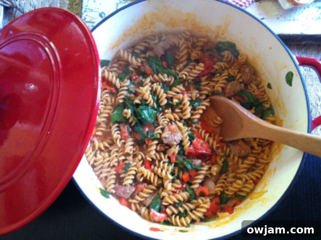 A large pot of freshly cooked Skillet Sausage and Spinach Pasta, ready to be served, showcasing the rich sauce, pasta, and vibrant spinach.