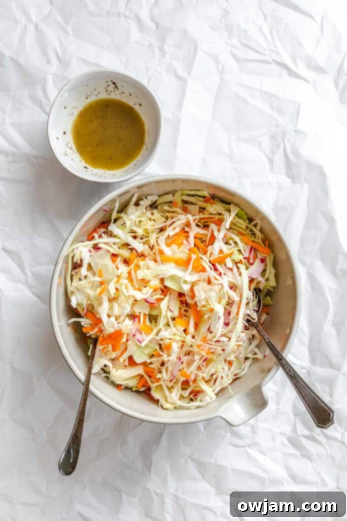 Lightened Up Coleslaw 11 Pouring the healthy vinaigrette dressing over the mixed coleslaw vegetables.