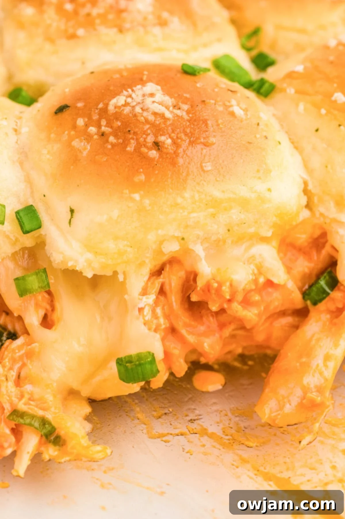 Effortless Buffalo Chicken Sliders 2 Easy Buffalo Chicken Sliders on a plate with green onions