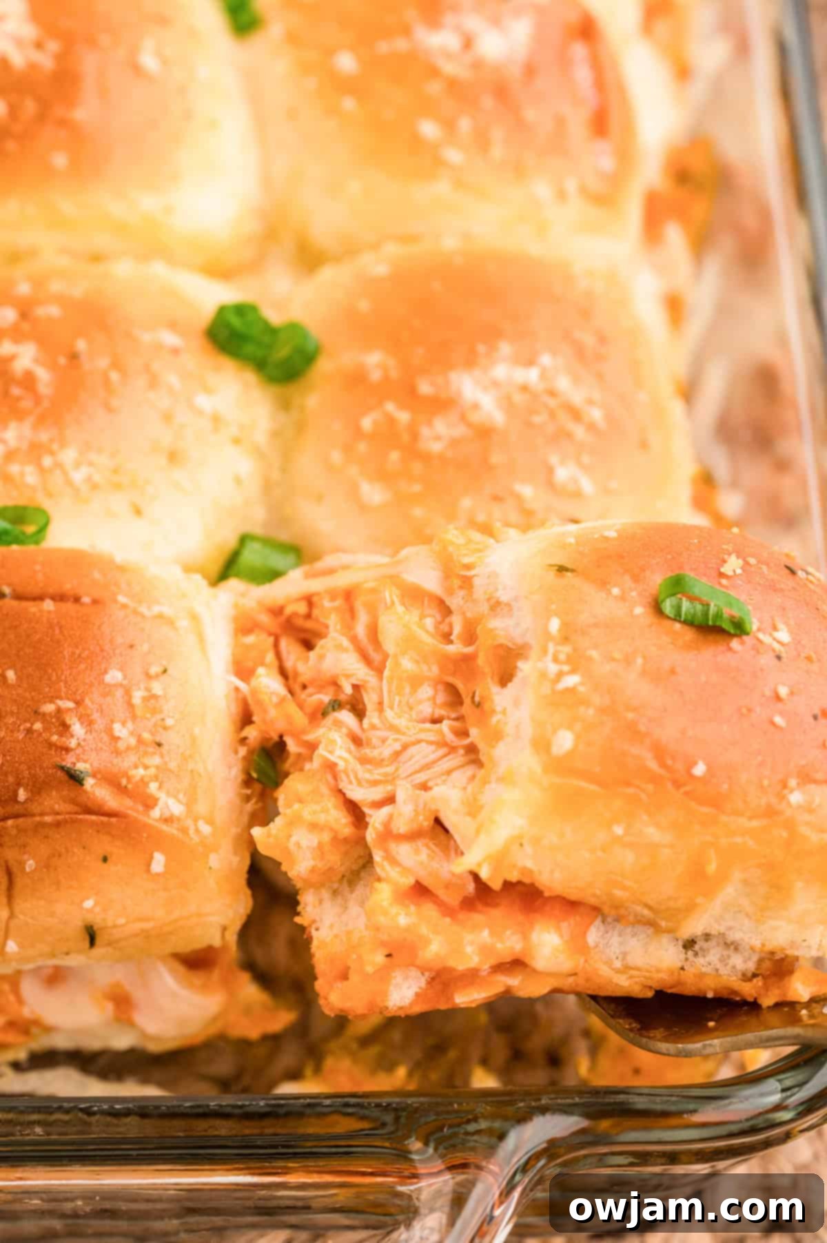 Effortless Buffalo Chicken Sliders 3 Easy Buffalo Chicken Sliders on a plate with green onions