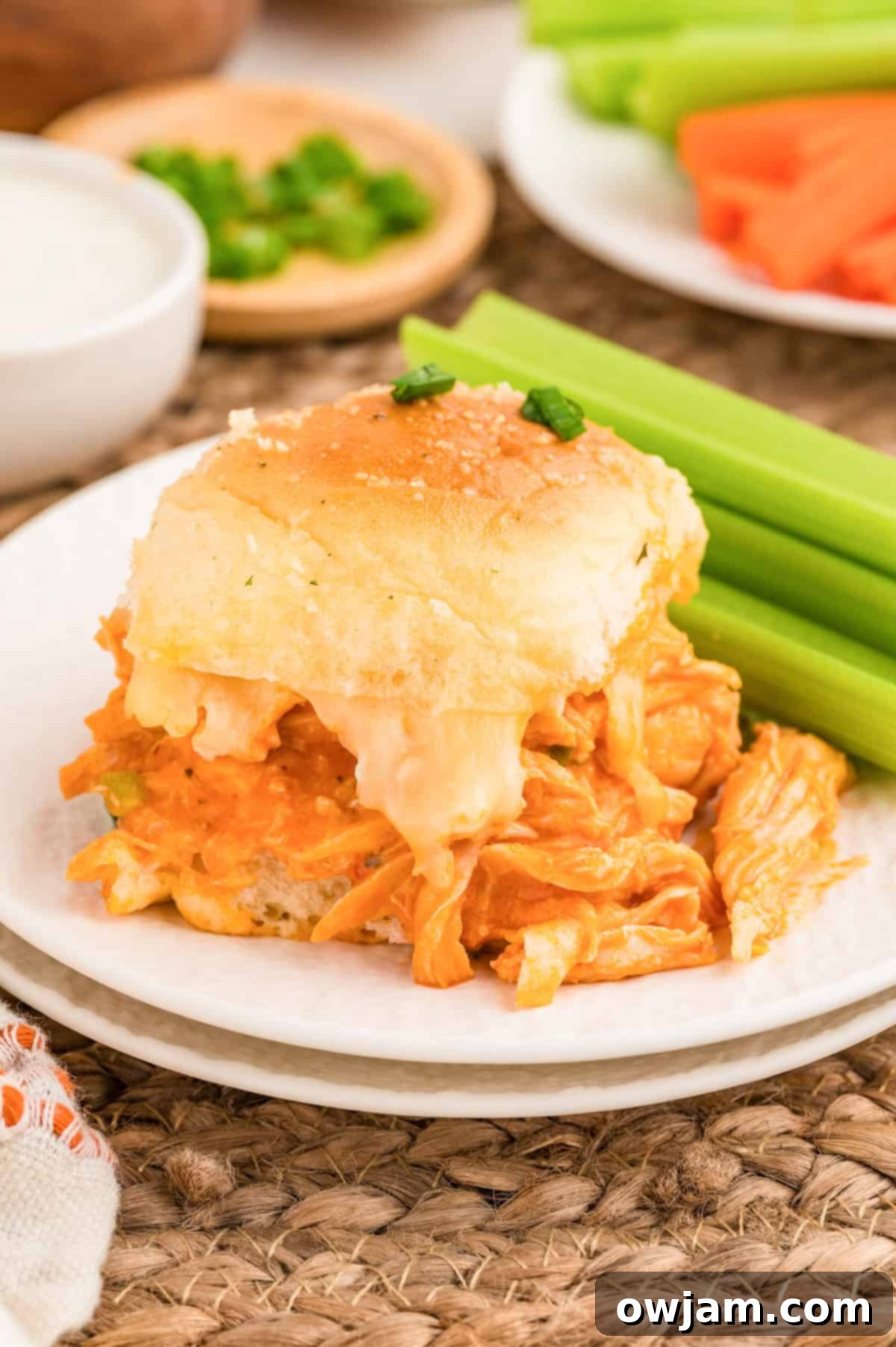 Effortless Buffalo Chicken Sliders 5 Easy Buffalo Chicken Sliders on a white plate with celery